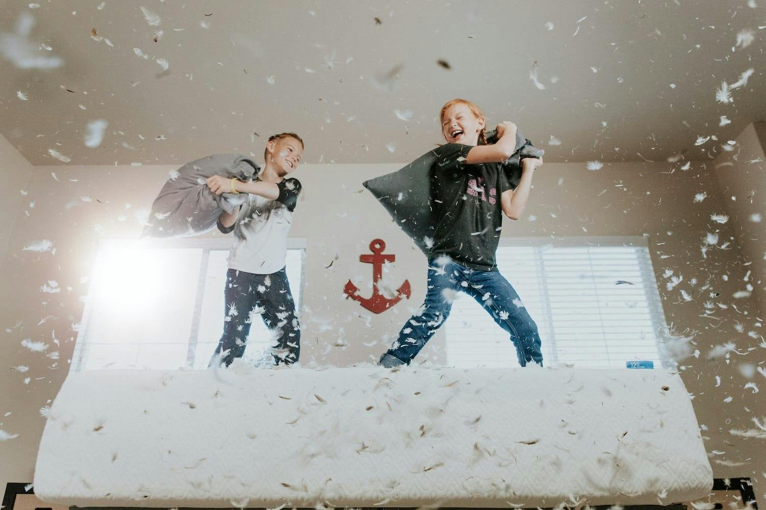 Image shows children having a pillow fight. 