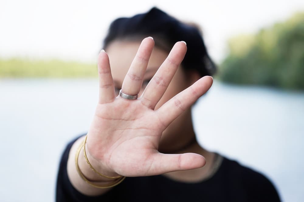 This is a photo of a woman hiding behind her hand