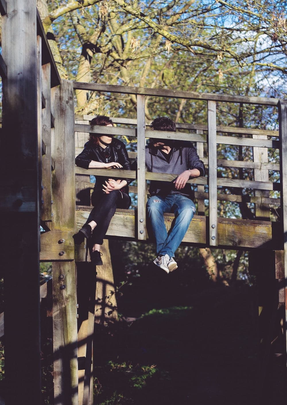 couple sitting on bridge talking