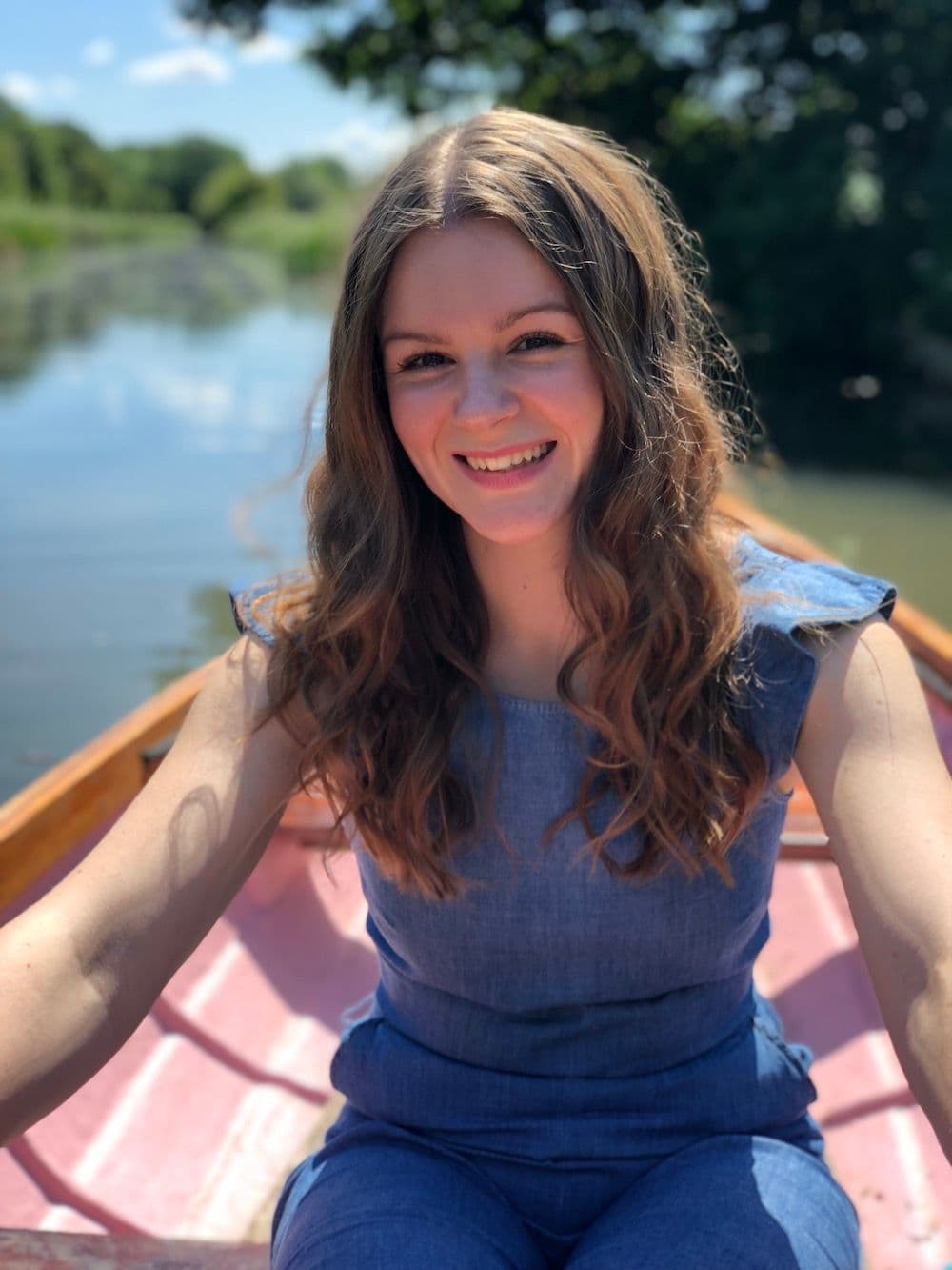 Author Becky Wright sitting in a rowing boat and smiling