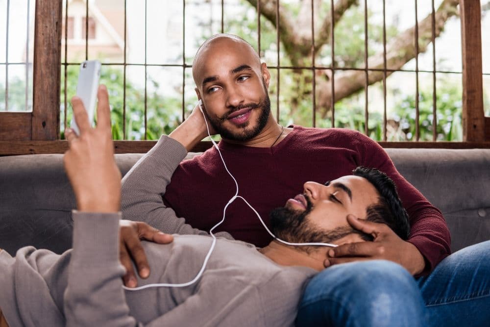 A couple listenes to music together on the sofa