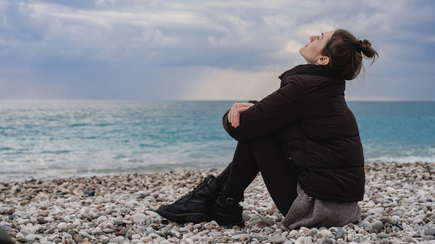 Person sat on a pebble beach