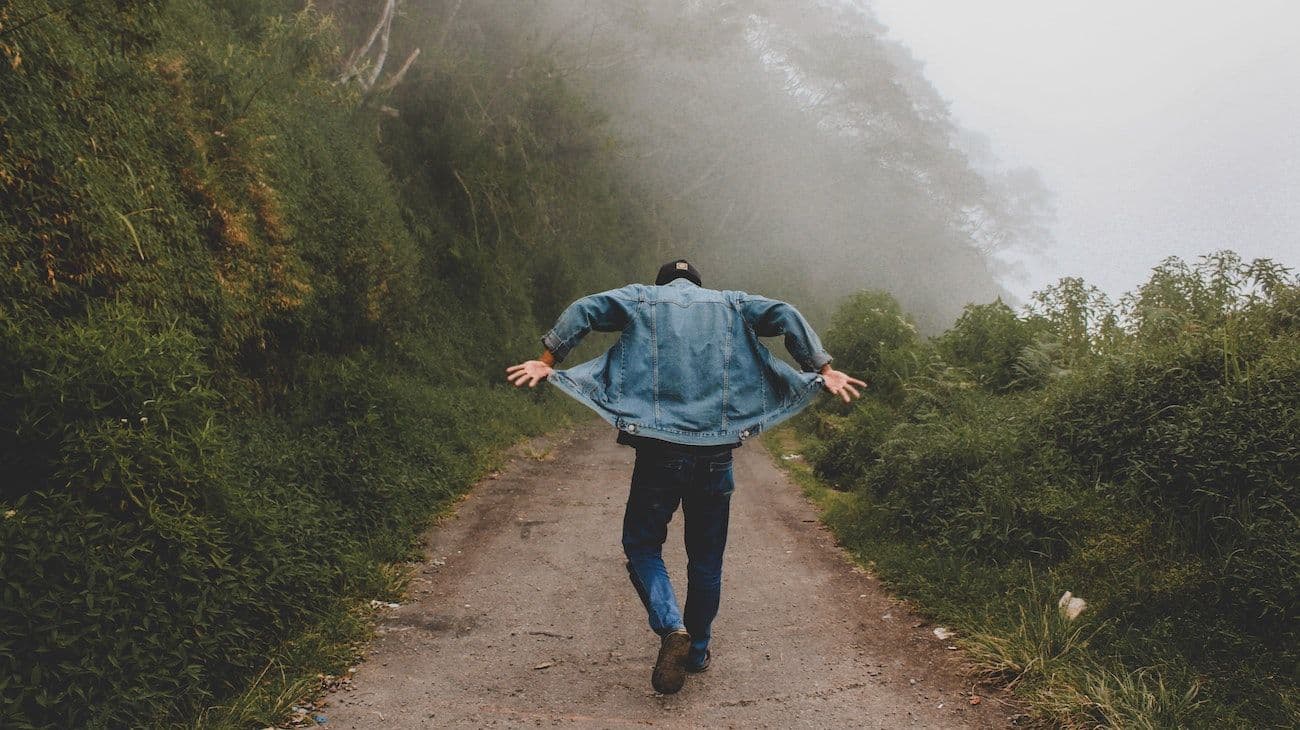 Man walking with arms out in nature