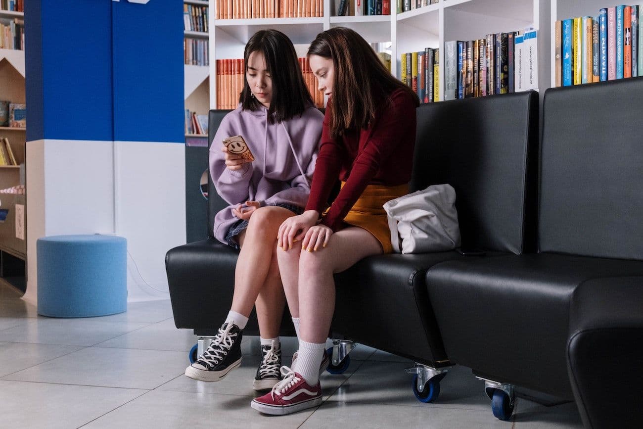 Two young girls looking at a phone
