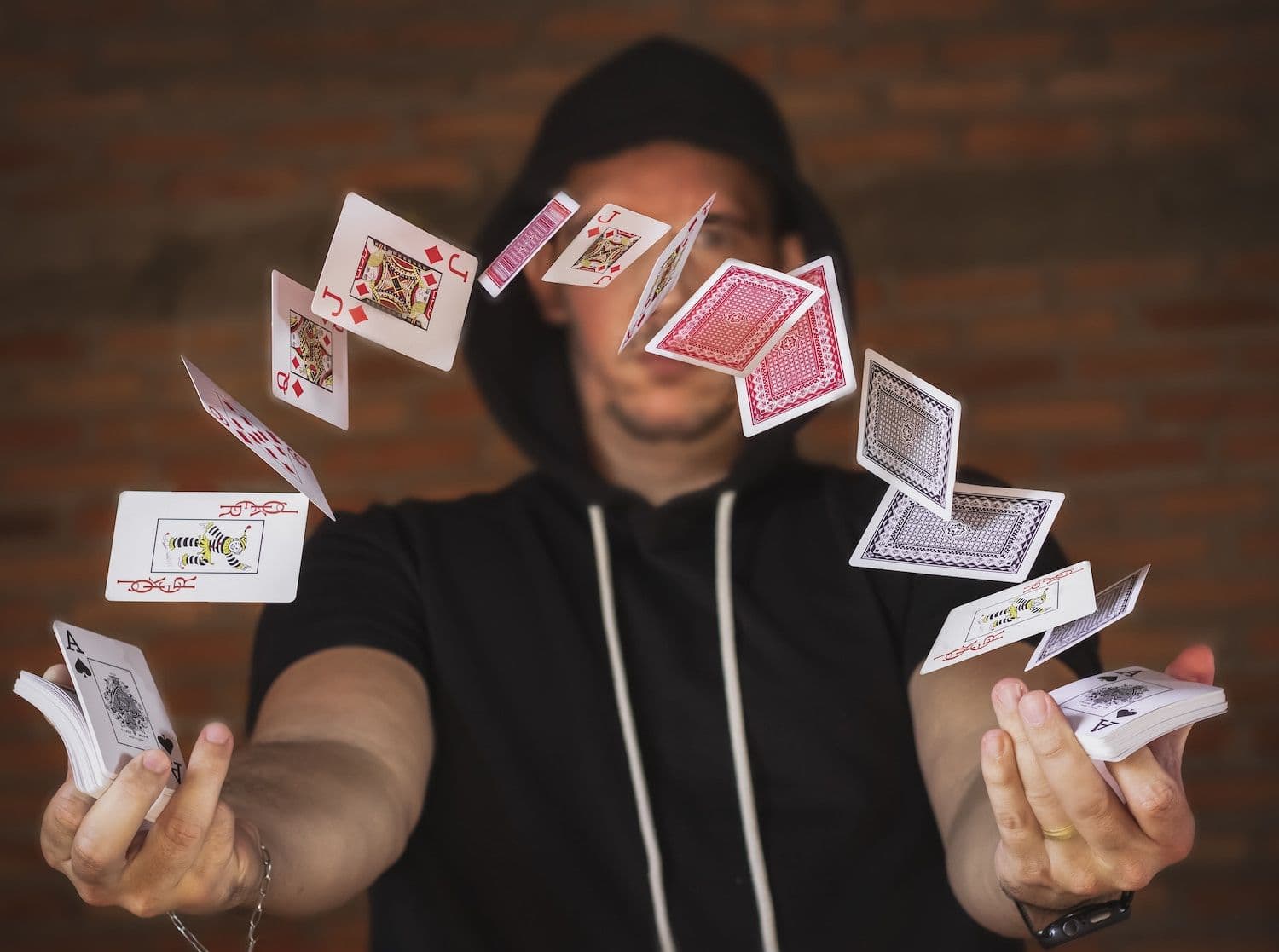 Image shows man throwing a deck of cards.