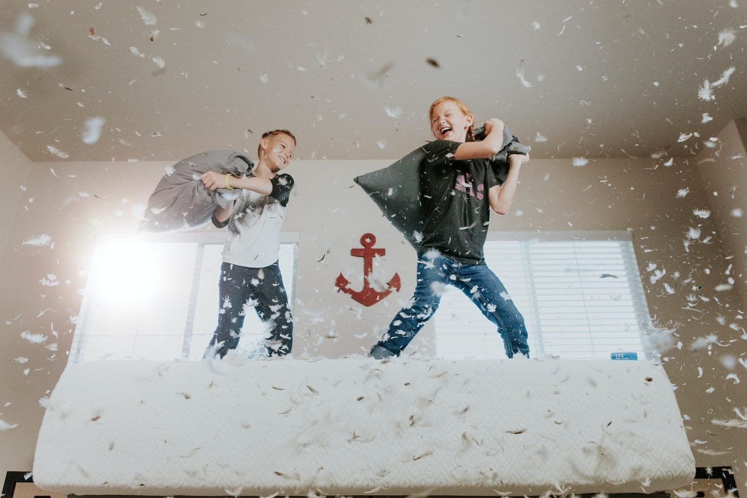 Image shows children having a pillow fight.