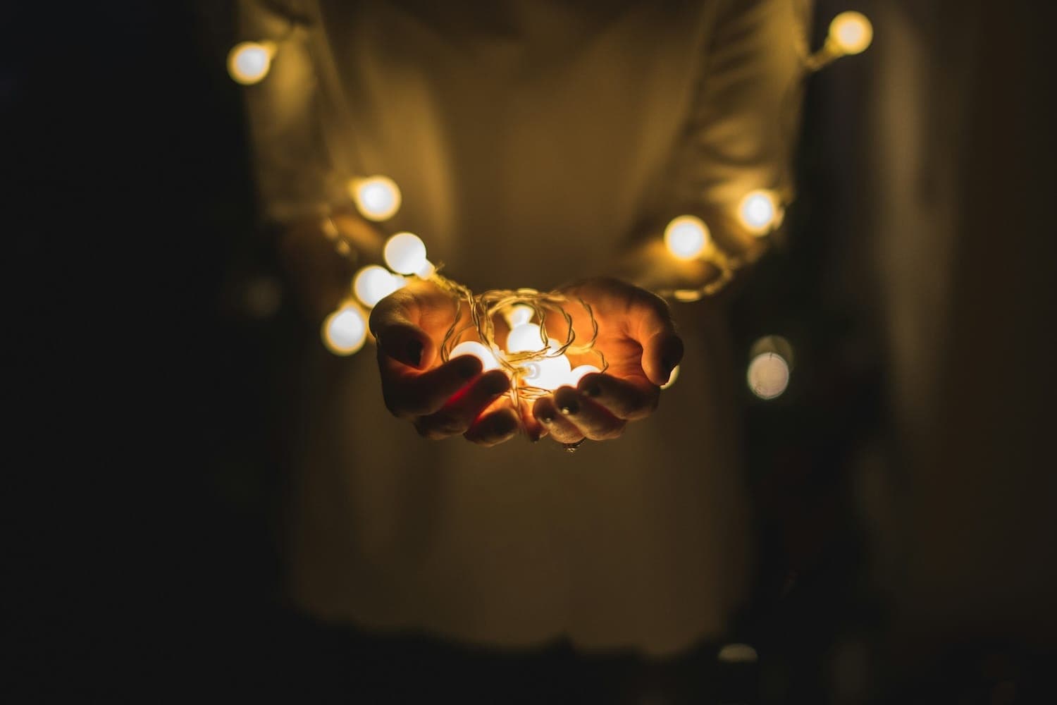 Image shows person holding fairy lights.