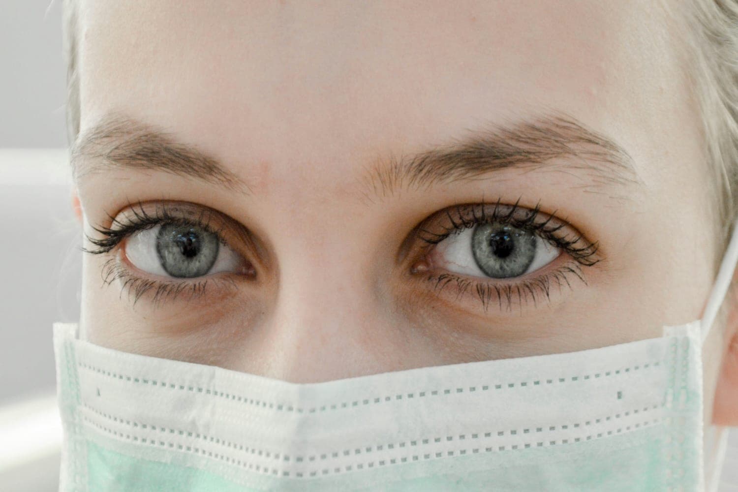 Image shows a nurse up close wearing a face mask.